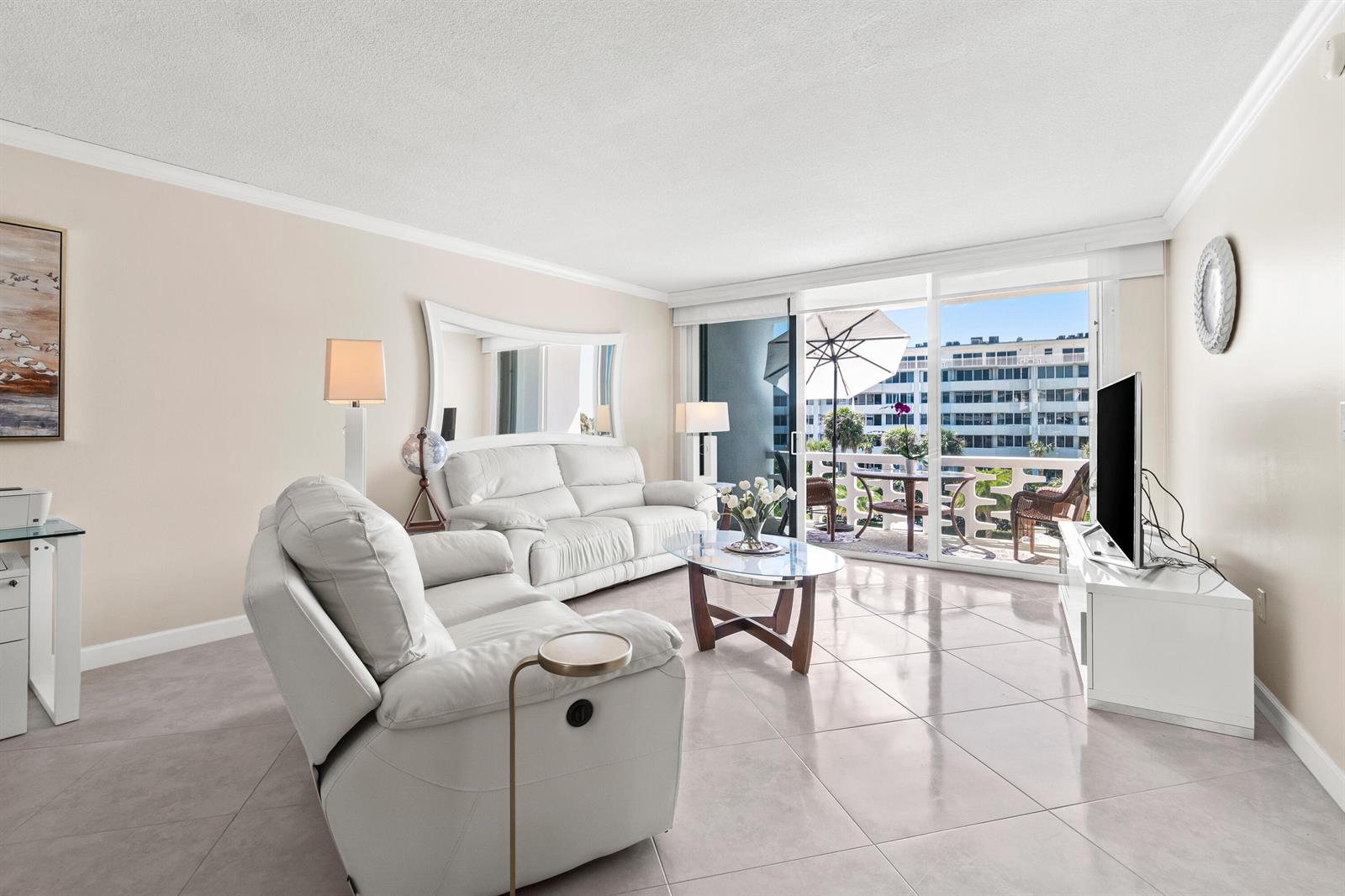 A bright living room features white leather furniture, tile flooring, and a balcony with outdoor seating — 2760 S Ocean Boulevard # 313, Palm Beach FL 33480, PALM BEACH, FL