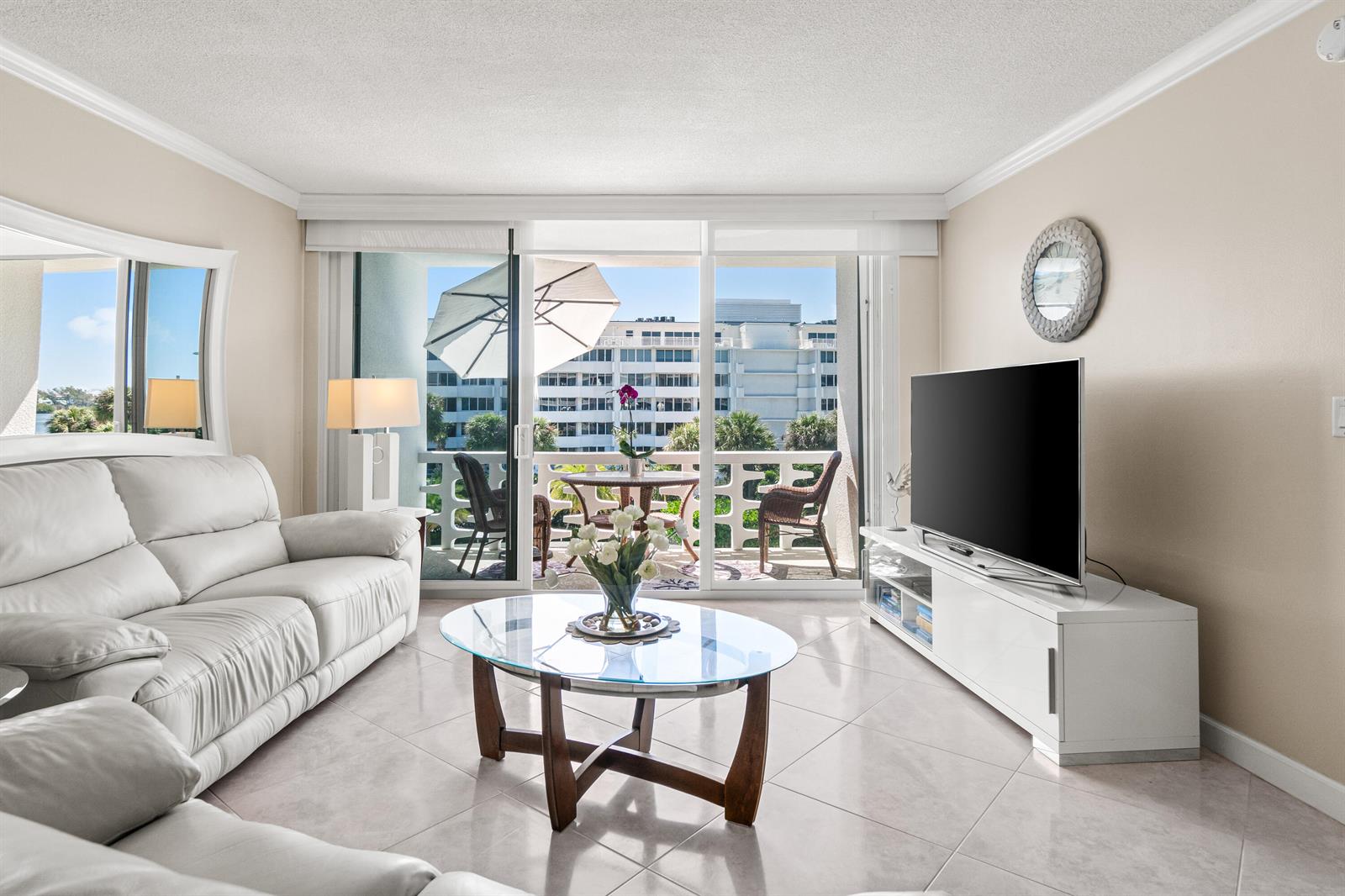 A living room features a white leather sofa, glass coffee table, and balcony with outdoor seating — 2760 S Ocean Boulevard # 313, Palm Beach FL 33480, PALM BEACH, FL