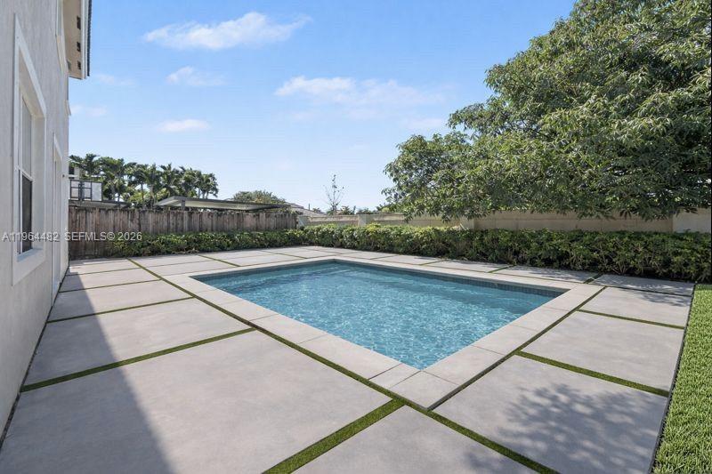 A rectangular swimming pool is surrounded by large concrete pavers with grass joints — 9260 SW 153rd Psge, Miami FL 33196, MIAMI, FL