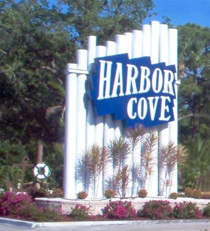 A white sign with the words Harbor Cove stands in front of trees and landscaping — 217 WOLVERINE AVENUE, NORTH PORT, FL