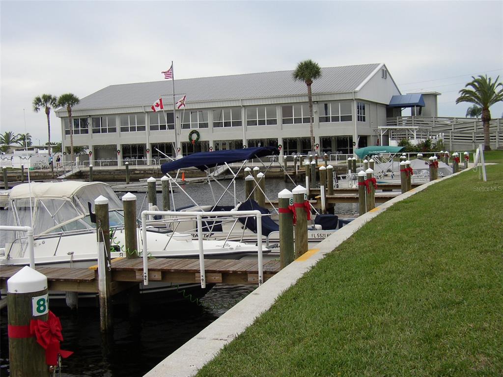 A marina features a large gray building with docked boats and festive holiday decorations — 217 WOLVERINE AVENUE, NORTH PORT, FL