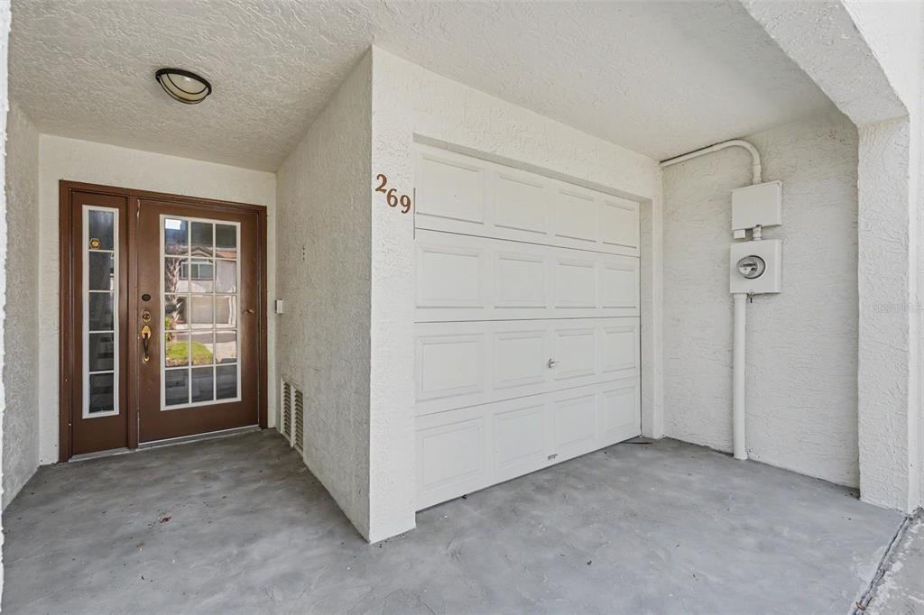 A white garage door and a brown front door are visible on this home exterior — 269 MADEIRA CIRCLE, ST PETERSBURG, FL