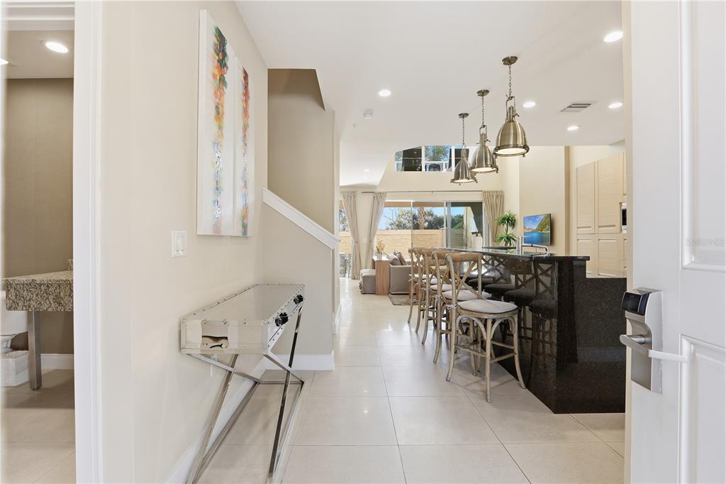 A view from an entryway into a kitchen with a breakfast bar and living area — 3113 BRASILIA AVENUE, KISSIMMEE, FL