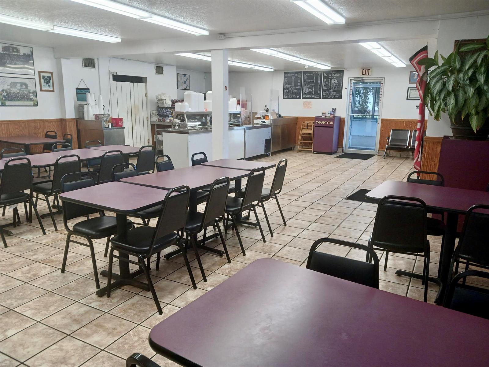 A dining area with purple tables, black chairs, tiled floors, and a service counter — 149 S Lake Avenue, Pahokee FL 33476, PAHOKEE, FL