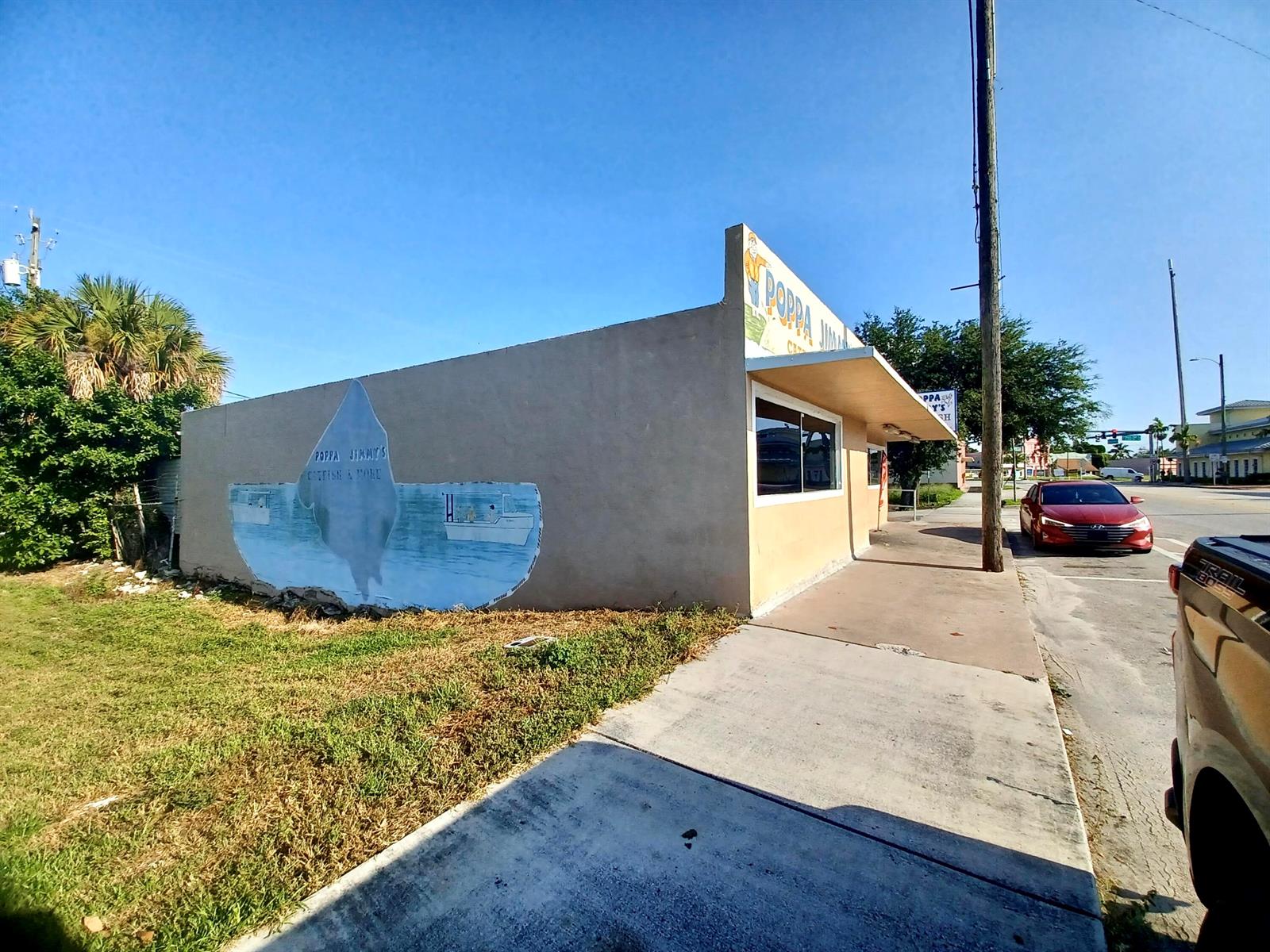A tan commercial building features a mural of a boat and the name Poppa Jimmy's — 149 S Lake Avenue, Pahokee FL 33476, PAHOKEE, FL