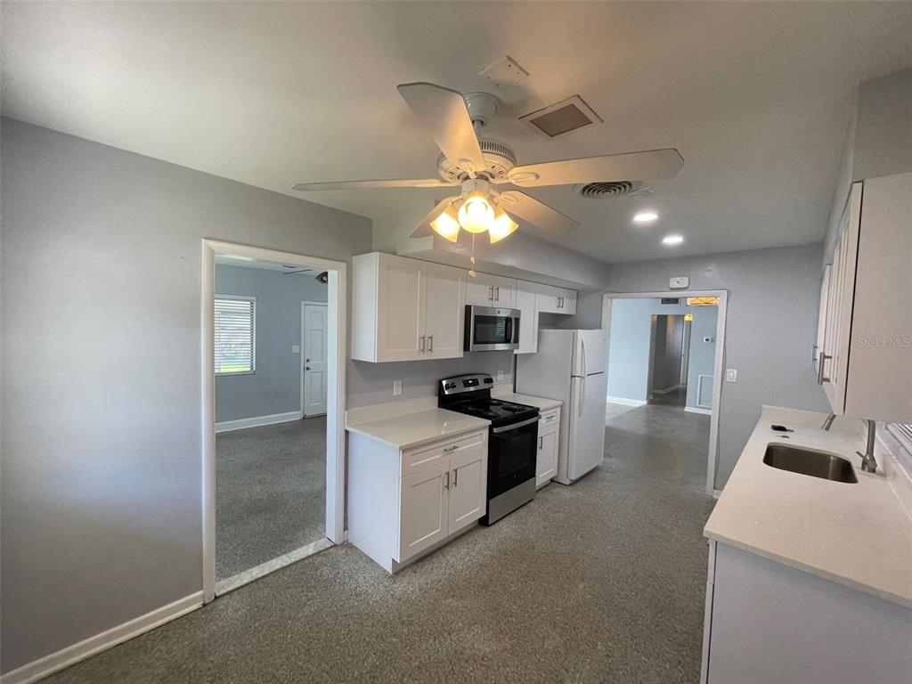 A kitchen with white cabinets, stainless steel appliances, and light gray walls — 520 SENECA TRAIL, MAITLAND, FL