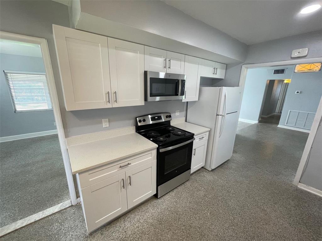 A kitchen features white cabinets, stainless steel appliances, and light-colored countertops — 520 SENECA TRAIL, MAITLAND, FL