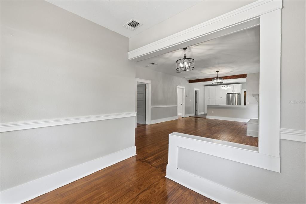 A view from a hallway into an open-concept living area with hardwood floors and cabinetry — 236 W NORTH STREET, TAMPA, FL