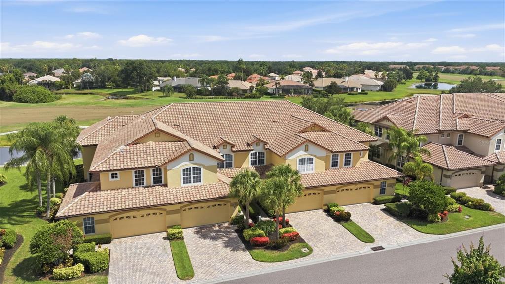 An aerial view of a two-story residential building with a tile roof and paved driveways — 8434 MIRAMAR WAY, LAKEWOOD RANCH, FL