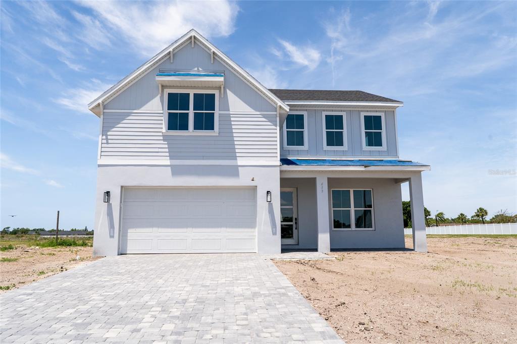 A two-story house with light gray siding, a paved driveway, and an attached garage — 659 MALDIVES TRAIL, SARASOTA, FL