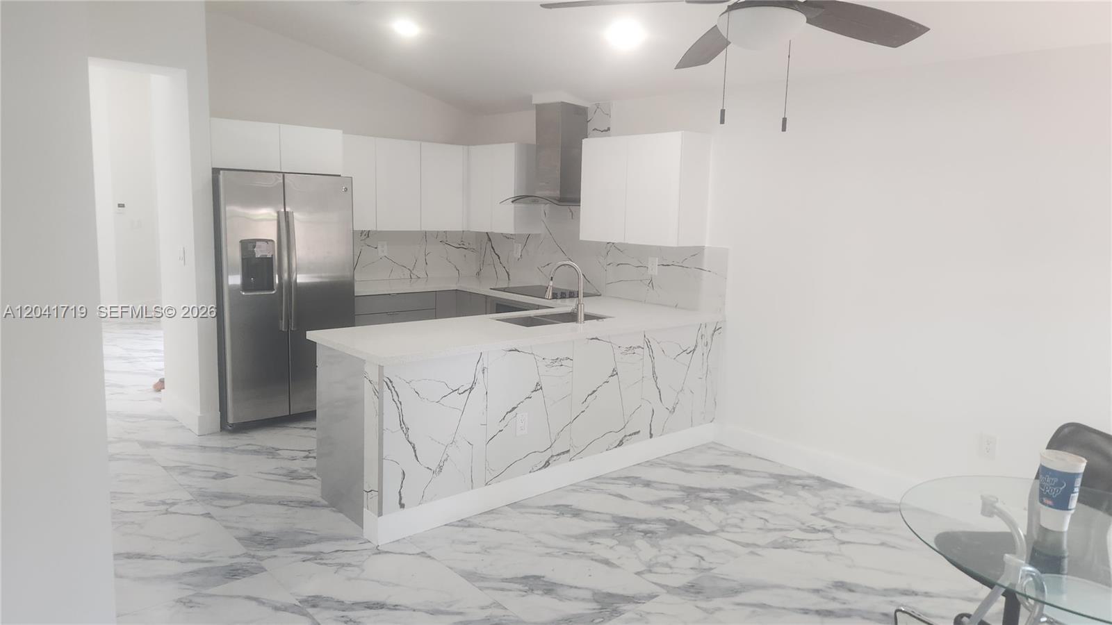 A kitchen with gray cabinets, white marble-patterned flooring, and a stainless steel range hood — 11491 SW 72nd Ter, Miami FL 33173, MIAMI, FL