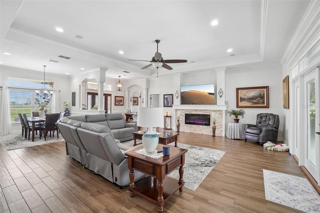 A spacious living room features a fireplace, gray sectional sofa, and wood-look tile flooring — 3934 CONNERSVILLE ROAD, BARTOW, FL