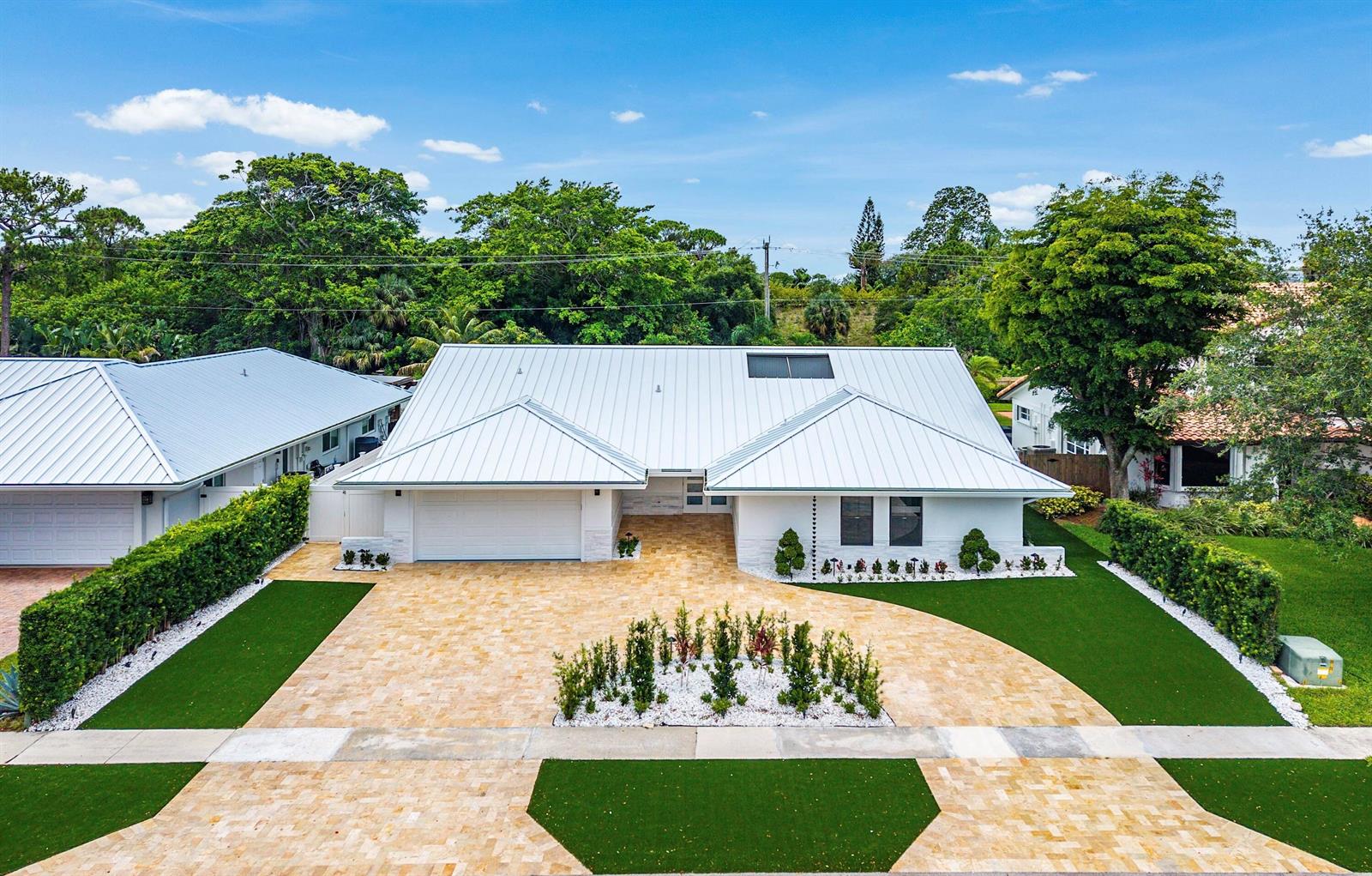 An aerial view of a single-story house with a white metal roof and paver driveway — 1520 SW 17th Street, Boca Raton FL 33486, BOCA RATON, FL