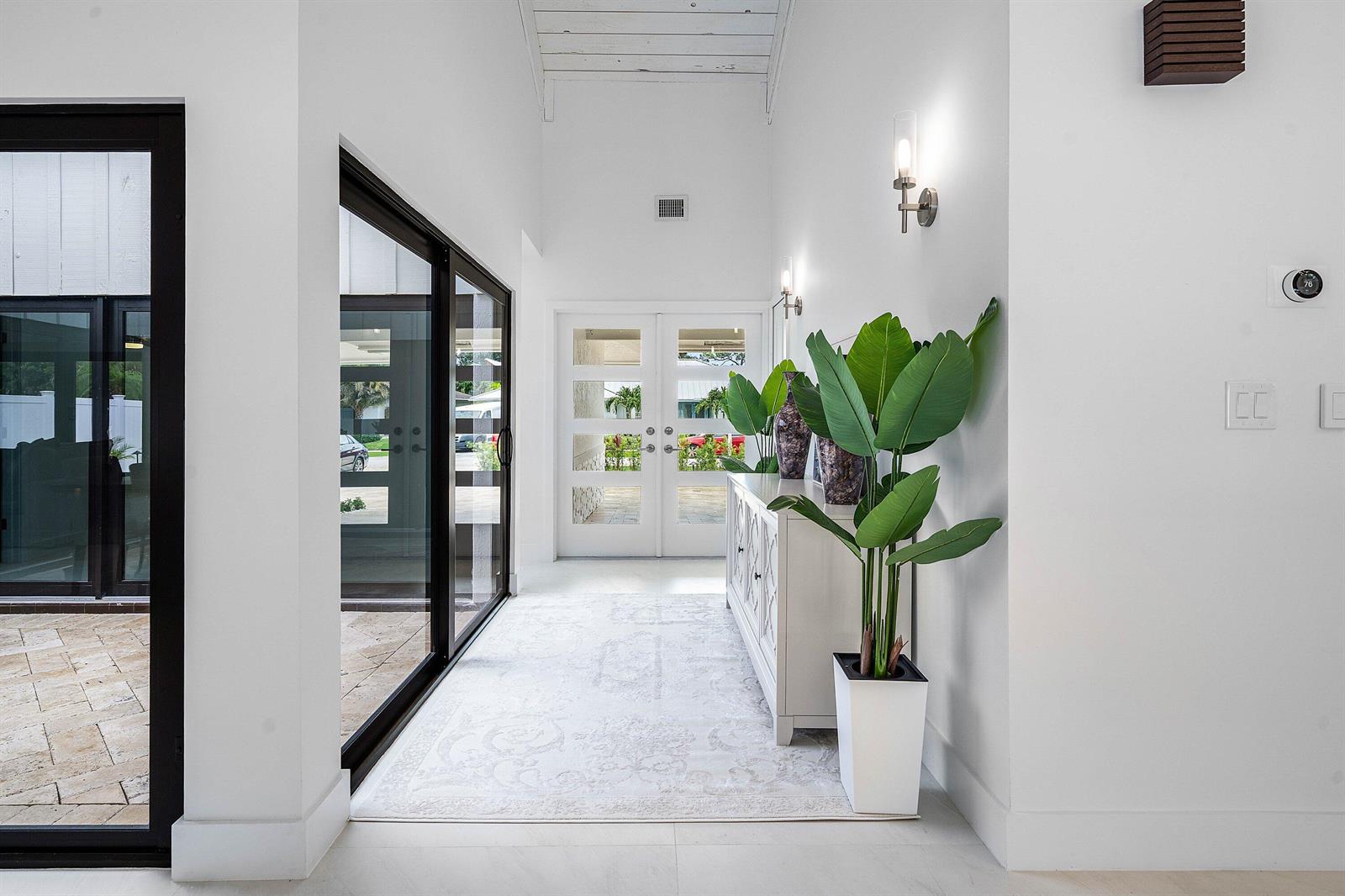 A bright entryway features white walls, a patterned rug, a console table, and glass doors — 1520 SW 17th Street, Boca Raton FL 33486, BOCA RATON, FL