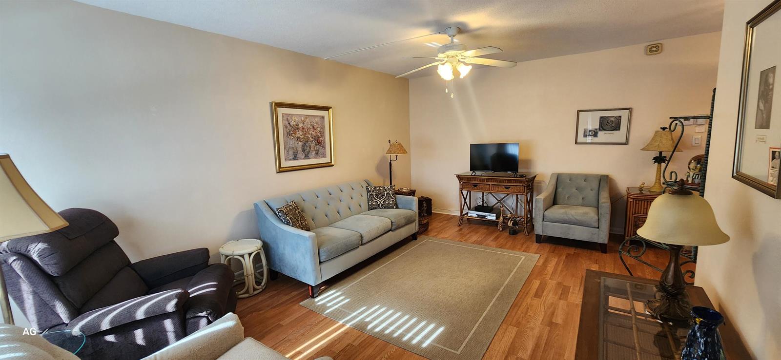 A living room features a blue sofa, a recliner, a television, and hardwood flooring — 15 SE 13th Street # D3, Boca Raton FL 33432, BOCA RATON, FL