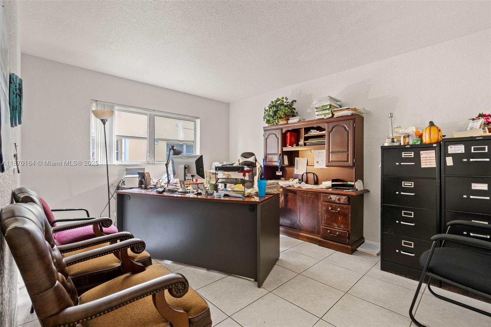 A home office features a wooden desk, a hutch, filing cabinets, and several chairs — 200 Croton Ave # 104, Lantana FL 33462, LANTANA, FL