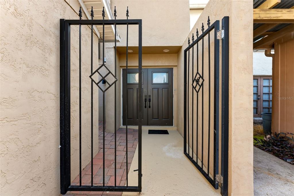 A gated entryway leads to a set of double front doors with a brick walkway — 105 E DAVIS BOULEVARD UNIT B, TAMPA, FL