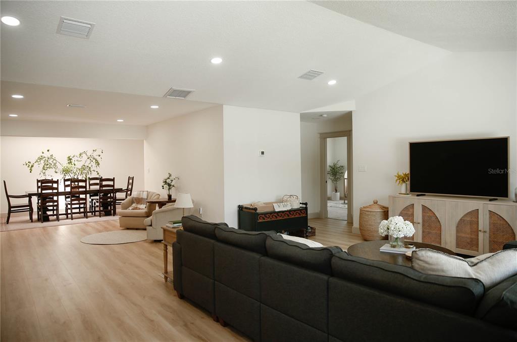A living room and dining area feature light wood flooring, recessed lighting, and neutral walls — 4646 GLEASON AVENUE, SARASOTA, FL