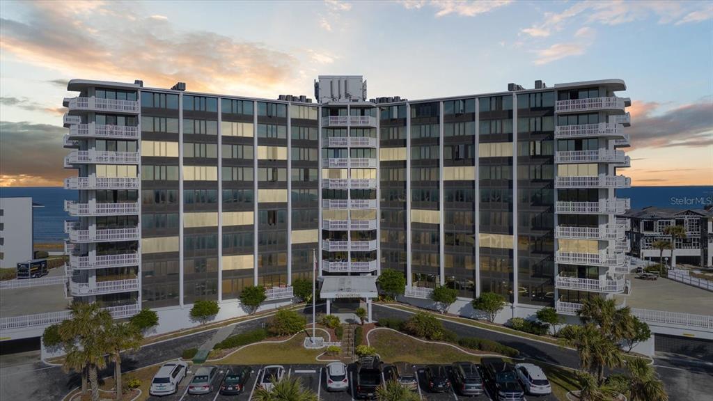 An aerial view of a multi-story beachfront condominium building with a parking lot in front — 3580 OCEAN SHORE BOULEVARD UNIT 101, FLAGLER BEACH, FL