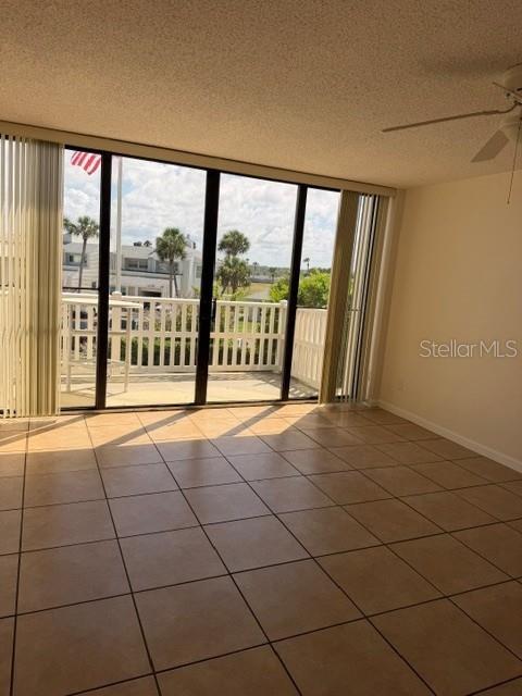 A room with tiled floors and large sliding glass doors leading to a balcony — 3580 OCEAN SHORE BOULEVARD UNIT 101, FLAGLER BEACH, FL