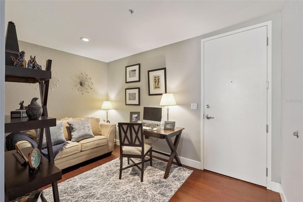 A home office features a desk, a sofa, a rug, and a white entry door — 150 E ROBINSON STREET UNIT 3104-1, ORLANDO, FL