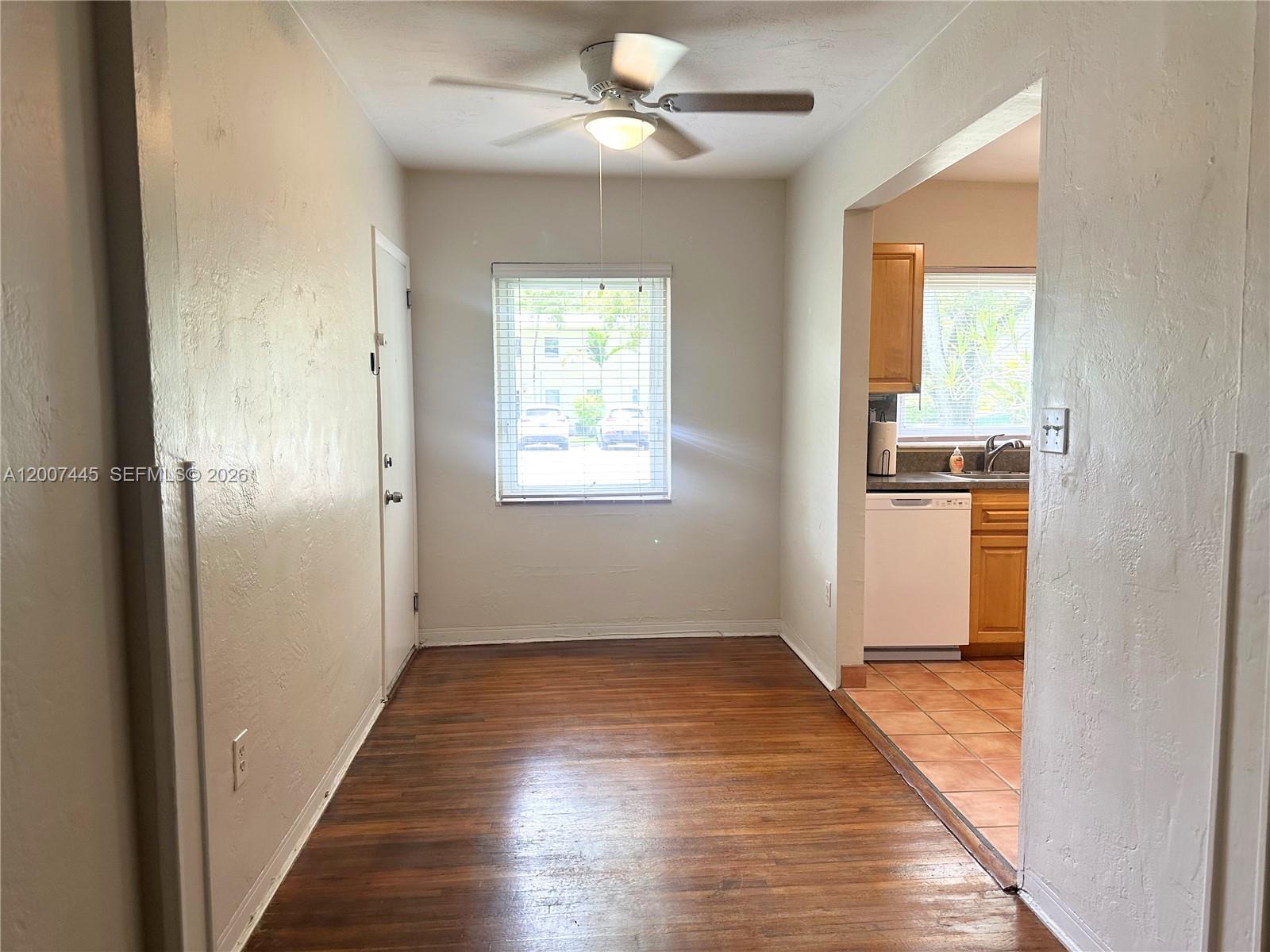 A dining area with wood flooring and a ceiling fan leads into a tiled kitchen — 7734 SW 55th Ave # B, Miami FL 33143, MIAMI, FL