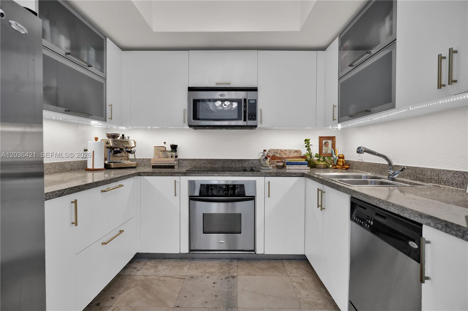 A modern kitchen features white cabinets, stainless steel appliances, and granite countertops — 500 NE 29th St # 901, Miami FL 33137, MIAMI, FL