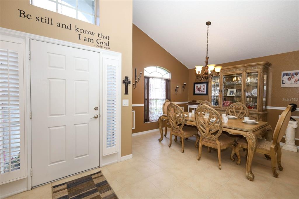 A dining room with a wooden table and chairs sits beside an entryway with tile floors — 5467 WARD LAKE DRIVE, PORT ORANGE, FL