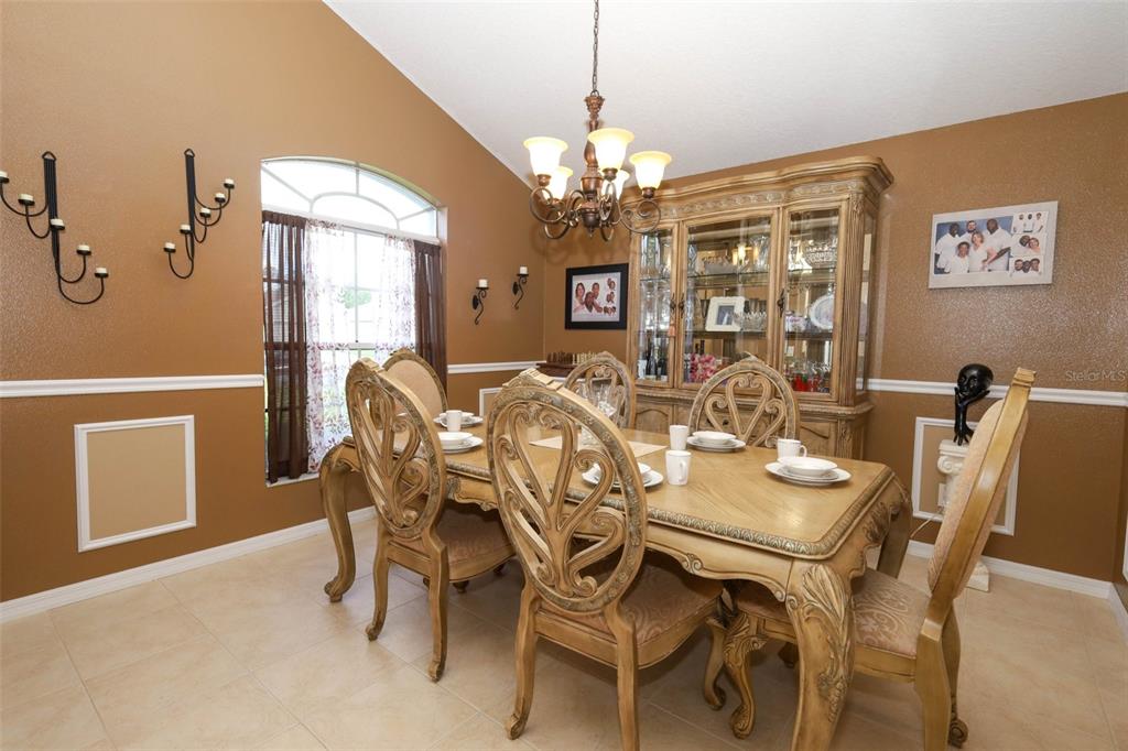 A dining room features a wooden table and chairs, a hutch, and tan walls — 5467 WARD LAKE DRIVE, PORT ORANGE, FL