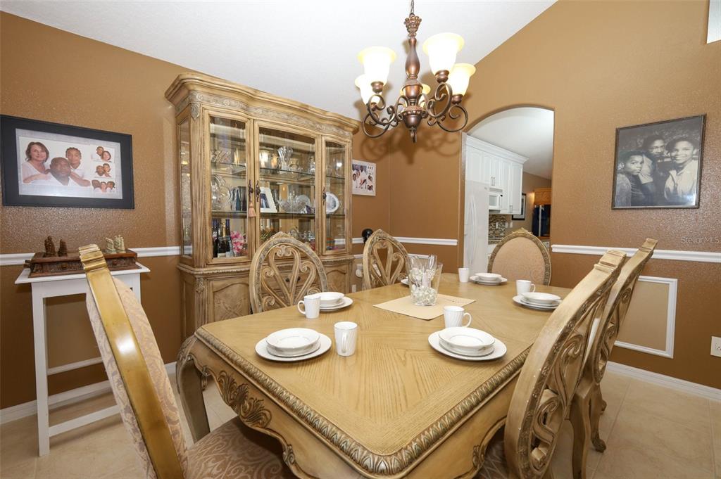 A dining room features a wooden table, chairs, a china cabinet, and a chandelier — 5467 WARD LAKE DRIVE, PORT ORANGE, FL