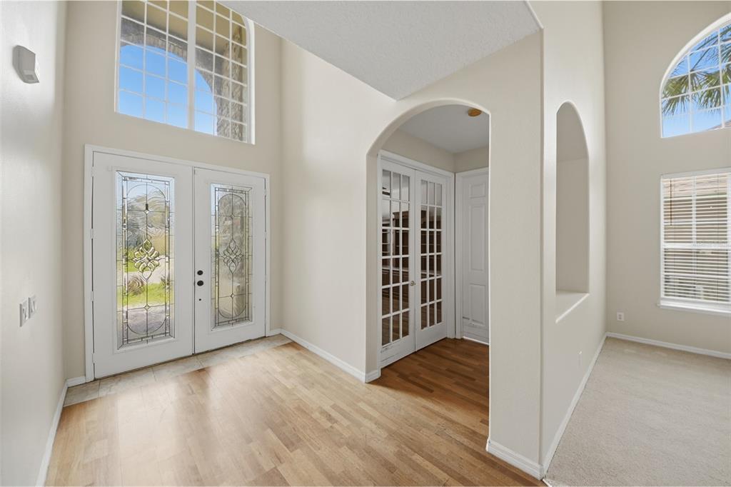 A bright foyer features hardwood floors, a double-door entrance, and an arched doorway to French doors — 11027 SUMMERSPRING LAKES DRIVE, ORLANDO, FL
