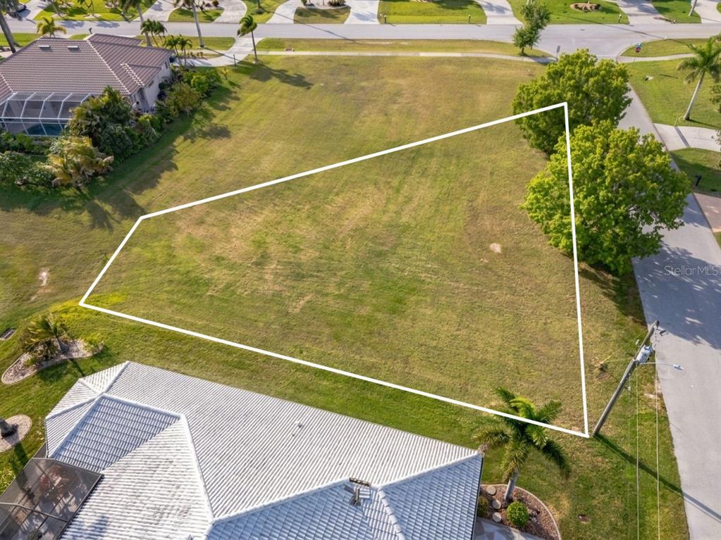 An aerial view shows a vacant, irregularly shaped residential lot outlined in white — 3707 BORDEAUX DRIVE, PUNTA GORDA, FL