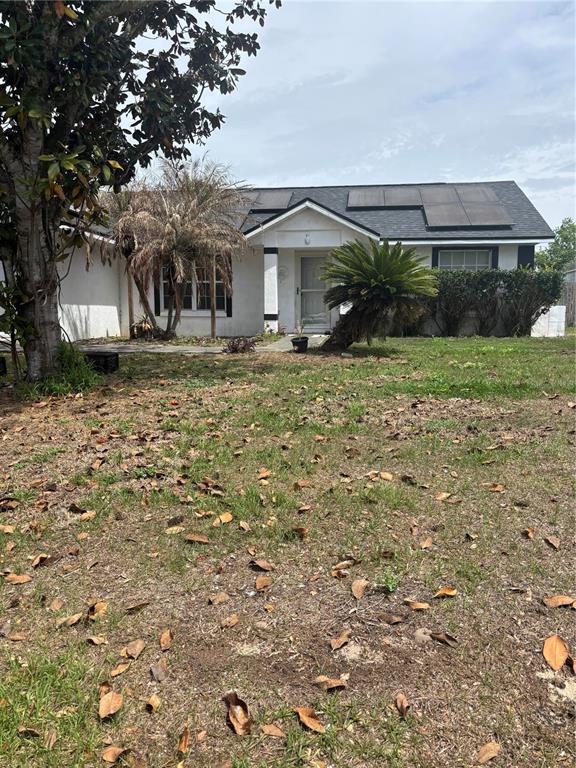 A single-story house with a white exterior, dark roof, and solar panels — 4250 WORTHINGTON PLACE, MASCOTTE, FL