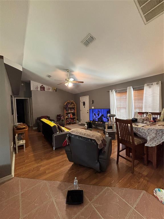 An open-concept living and dining area features hardwood floors, a ceiling fan, and gray walls — 4250 WORTHINGTON PLACE, MASCOTTE, FL