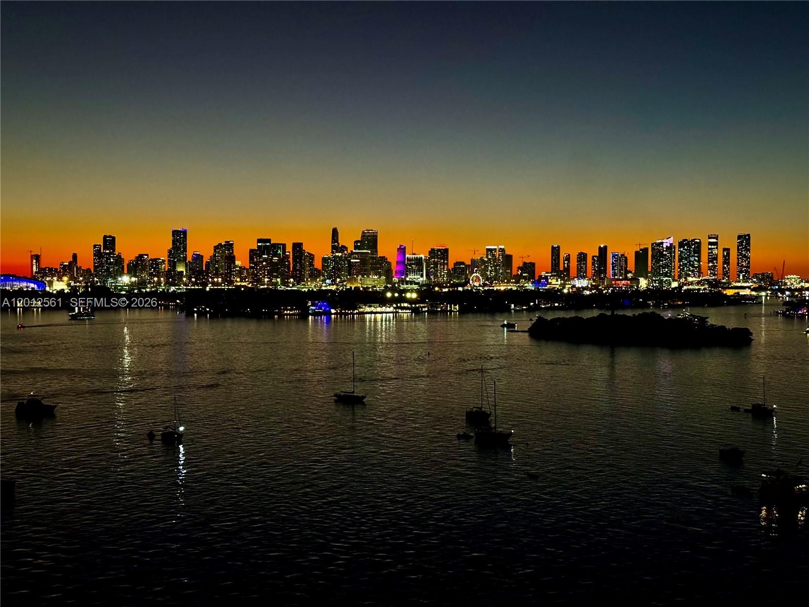 A wide-angle view of the Miami skyline at sunset across a body of water — 1500 Bay Rd # 1438S, Miami Beach FL 33139, MIAMI BEACH, FL