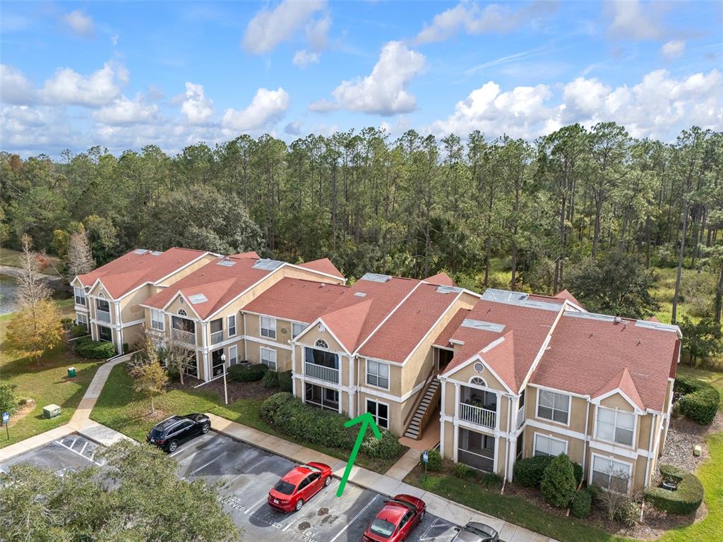 An aerial view shows a multi-story apartment building with a red roof and parking lot — 9481 HIGHLAND OAK DRIVE UNIT 1709, TAMPA, FL