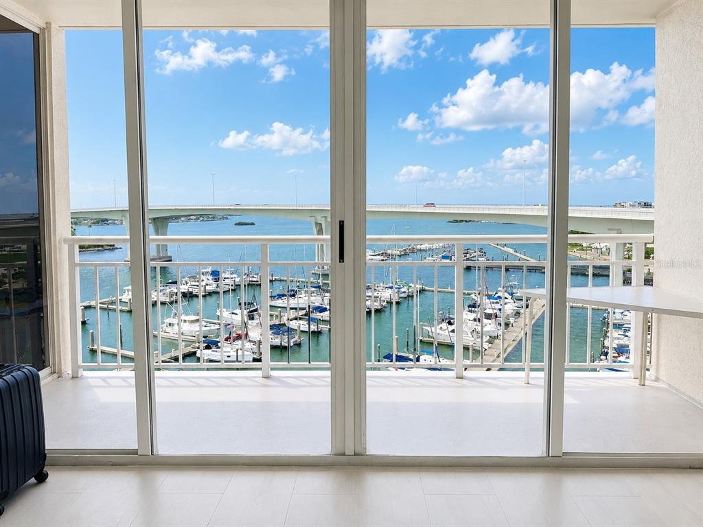 A balcony with a white railing overlooks a marina and a bridge under a blue sky — 100 PIERCE STREET UNIT 808, CLEARWATER, FL