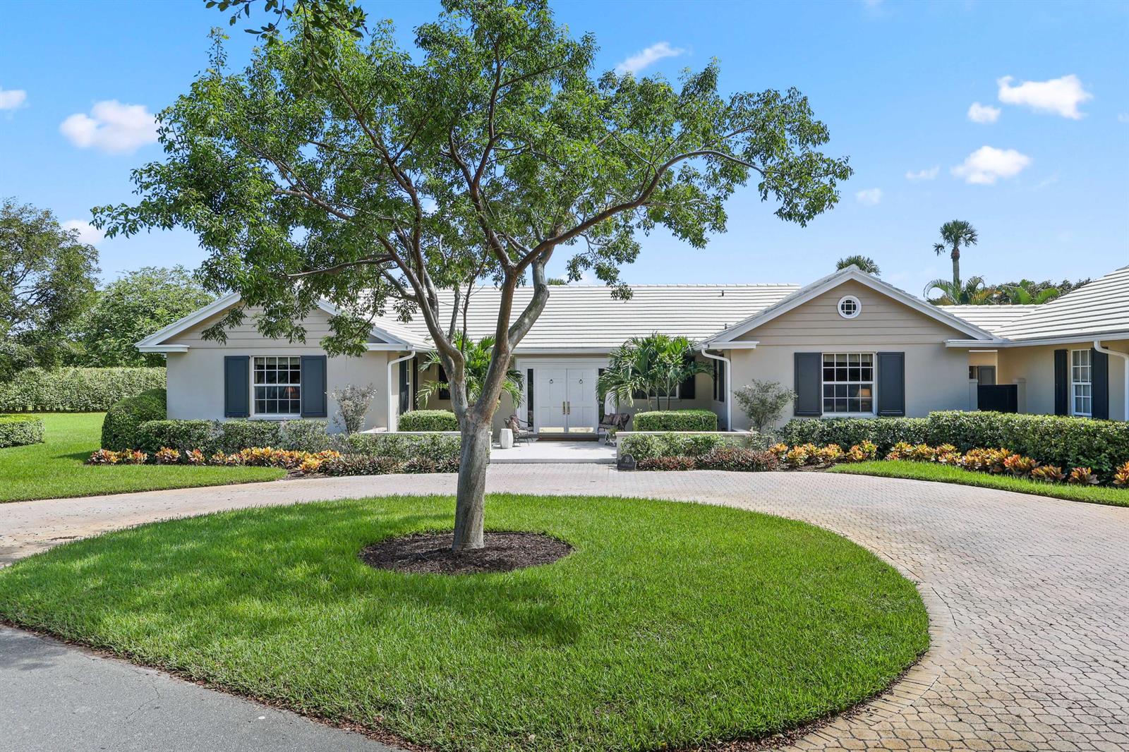 A single-story house with a circular driveway, a large tree, and manicured landscaping — 36 Country Road, FL 33436, FL