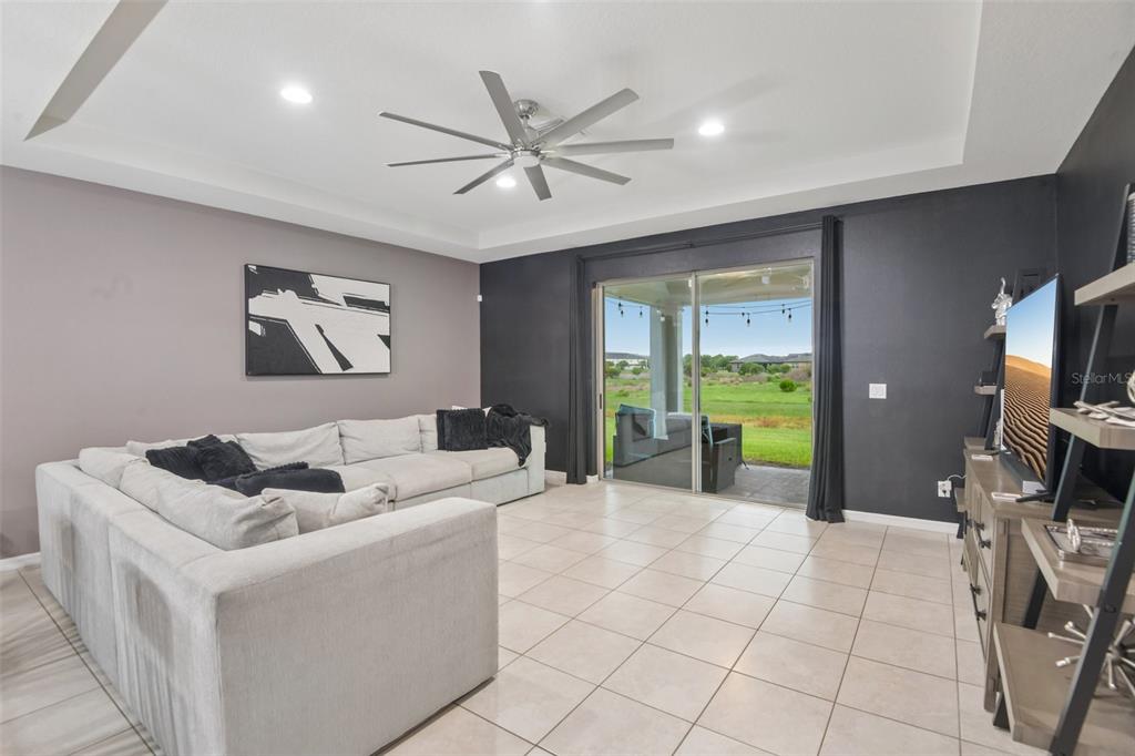 A living room features a large sectional sofa, a ceiling fan, and sliding glass doors — 5319 FALLEN LEAF DRIVE, RIVERVIEW, FL