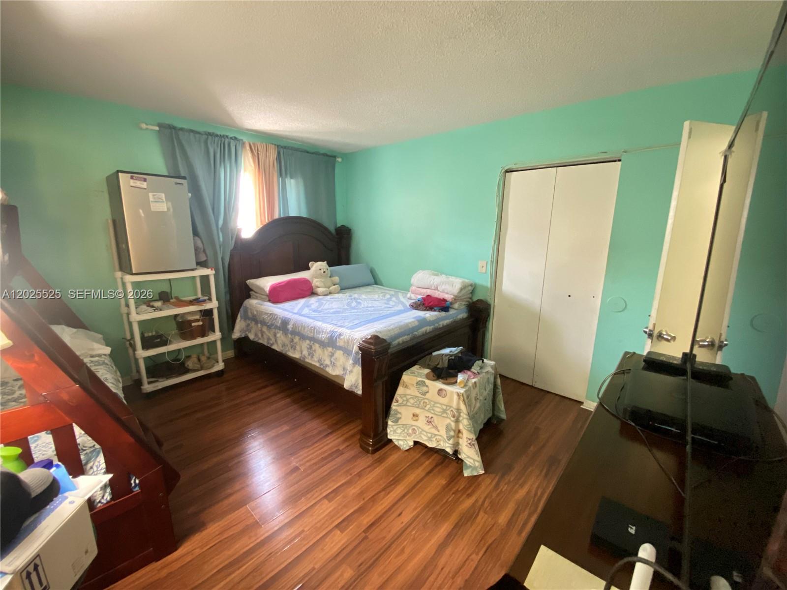 A bedroom features light green walls, wood-look flooring, a bed, and a bunk bed — 1702 S Dixie Hwy # 15, Lake Worth FL 33460, LAKE WORTH, FL