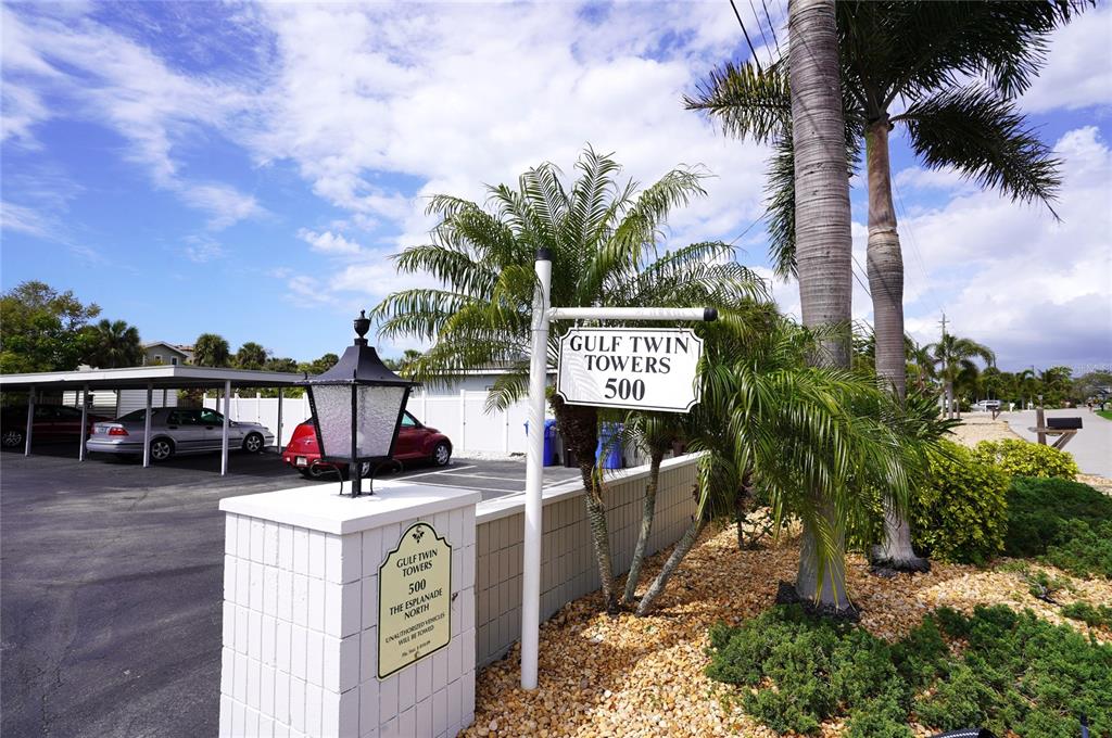 A sign for Gulf Twin Towers 500 stands in front of a parking area with palm trees — 500 THE ESPLANADE N UNIT 604, VENICE, FL