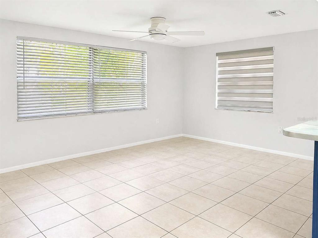 A room with light-colored tile flooring, white walls, a ceiling fan, and two windows — 7210 SAN MORITZ DRIVE, PORT RICHEY, FL