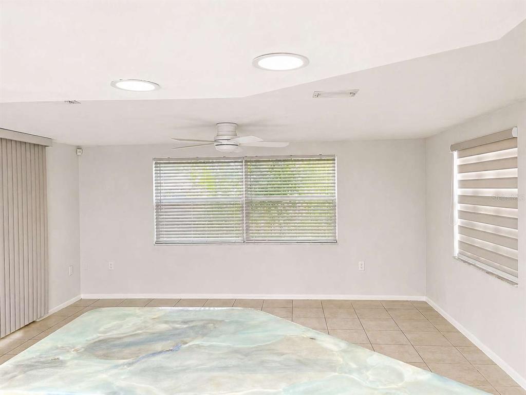 A living room with tile flooring, a ceiling fan, and windows with blinds — 7210 SAN MORITZ DRIVE, PORT RICHEY, FL
