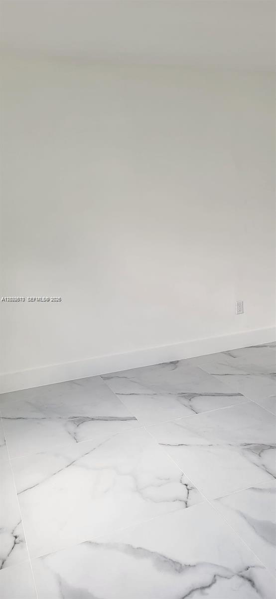 A room with white walls and light-colored marble-patterned tile flooring — 712 Hialeah Dr, Hialeah FL 33010, HIALEAH, FL