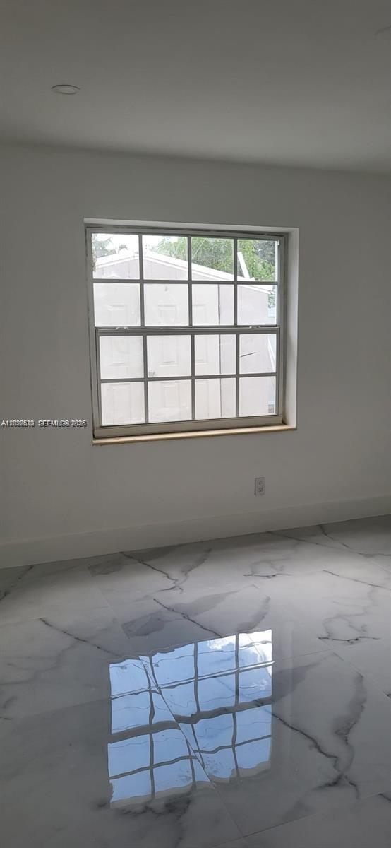 A room with white walls, a grid-patterned window, and polished white marble-look tile flooring — 712 Hialeah Dr, Hialeah FL 33010, HIALEAH, FL