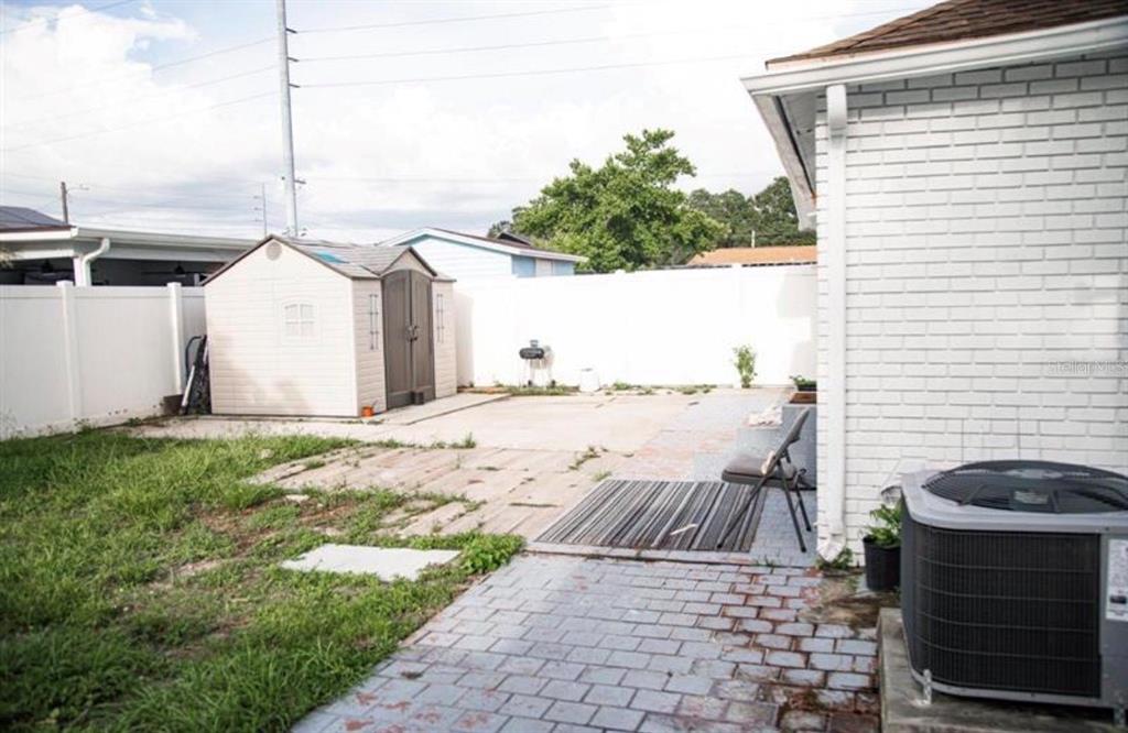 A backyard features a storage shed, a concrete patio, a brick walkway, and an AC unit — 2503 W MARQUETTE AVENUE, TAMPA, FL