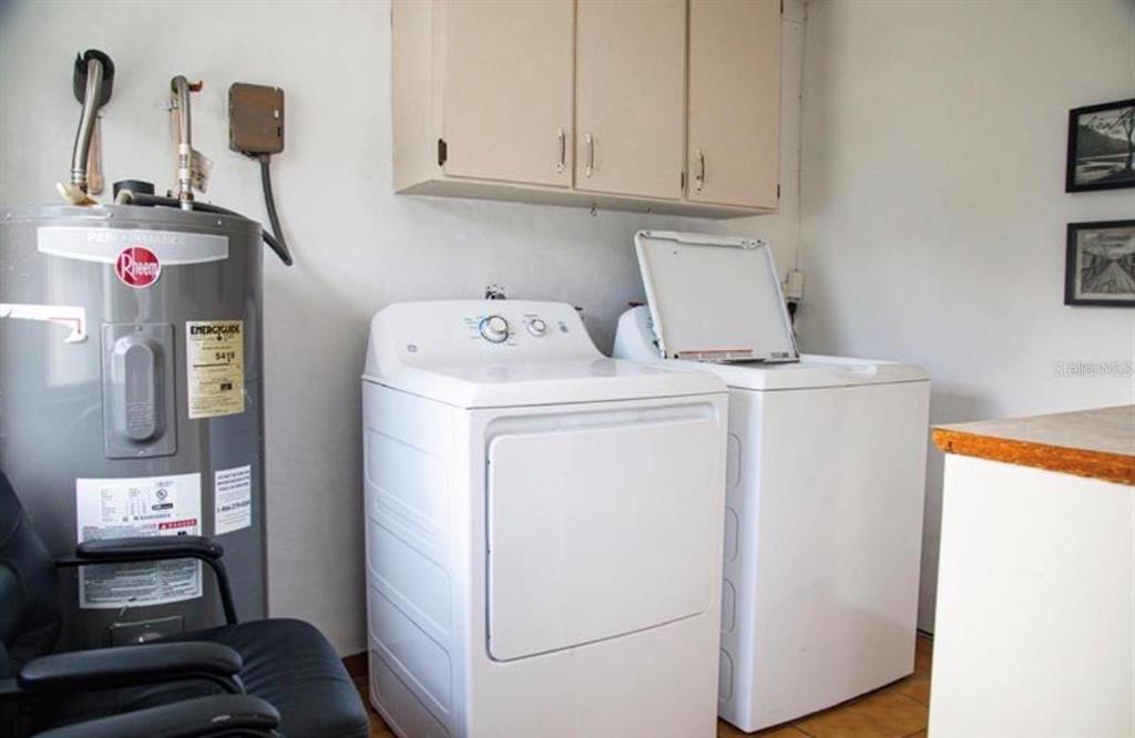 A laundry room features a water heater, a white washer, and a white dryer — 2503 W MARQUETTE AVENUE, TAMPA, FL