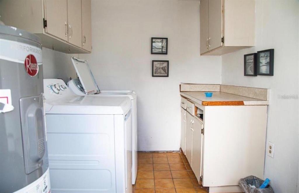 A laundry room features white appliances, beige cabinets, and tan floor tiles — 2503 W MARQUETTE AVENUE, TAMPA, FL