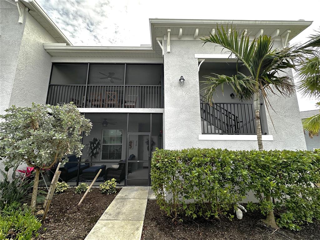 A two-story building exterior features a screened-in ground floor patio and an upper balcony — 14050 HERITAGE LANDING BOULEVARD UNIT 226, PUNTA GORDA, FL