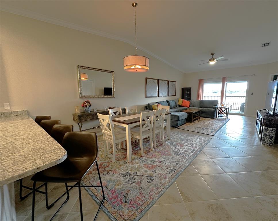 An open-concept living and dining area features tile flooring, a kitchen island, and neutral walls — 14050 HERITAGE LANDING BOULEVARD UNIT 226, PUNTA GORDA, FL